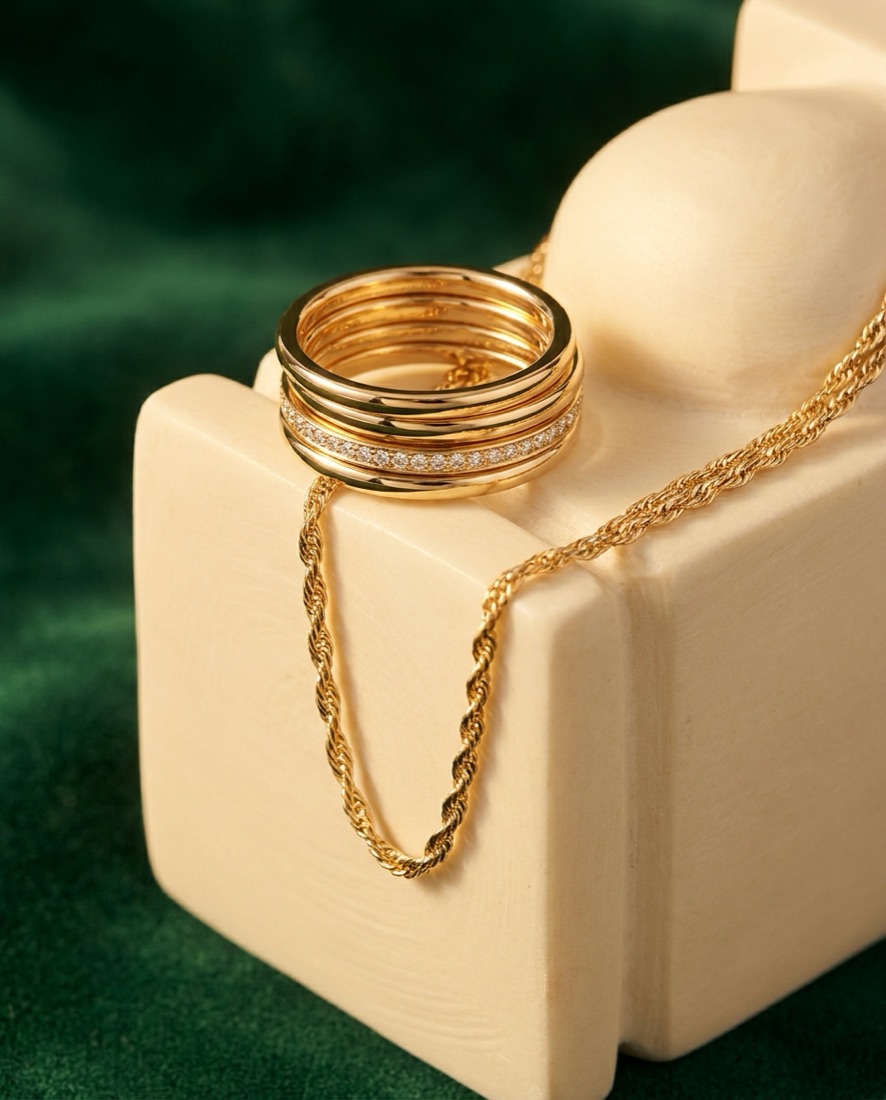 Jewelry campaign visual — gold rings on emerald velvet
